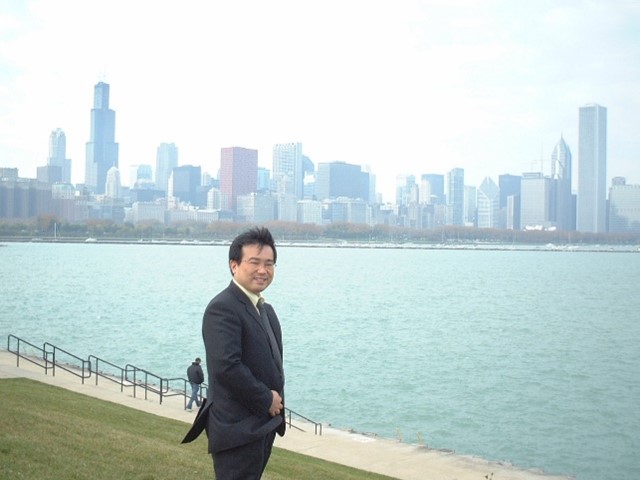 ダウンタウンシカゴを風景に微笑む綱島先生。