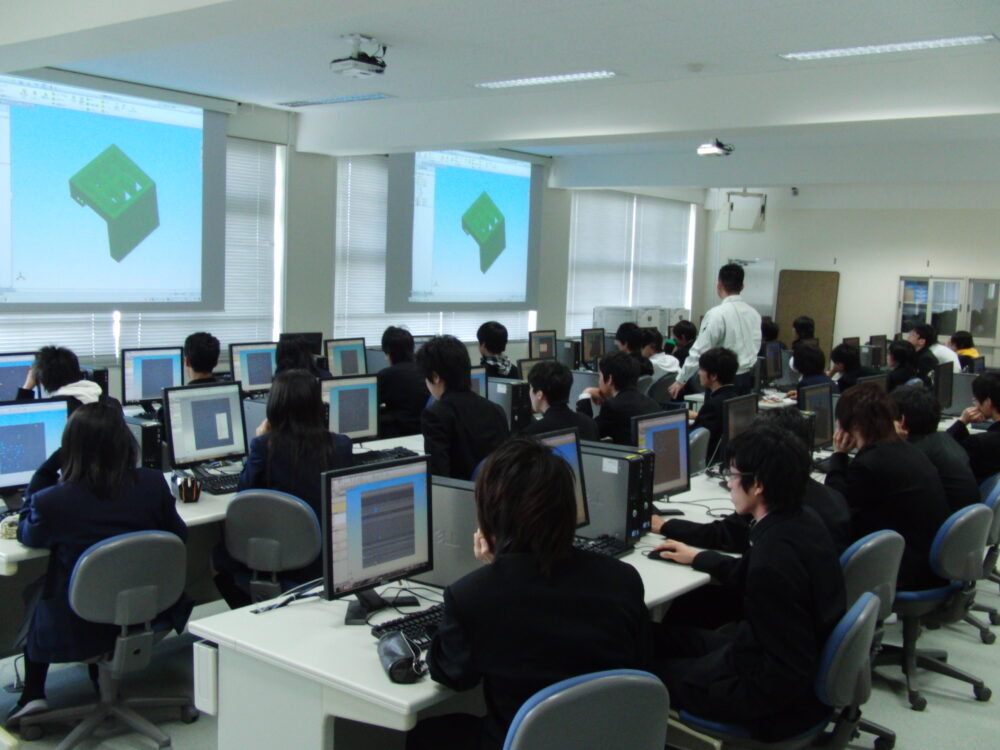 大きく映し出されたモニターにはCADの画面。学生はそれぞれのPCでソフトを触っている、教室での様子。