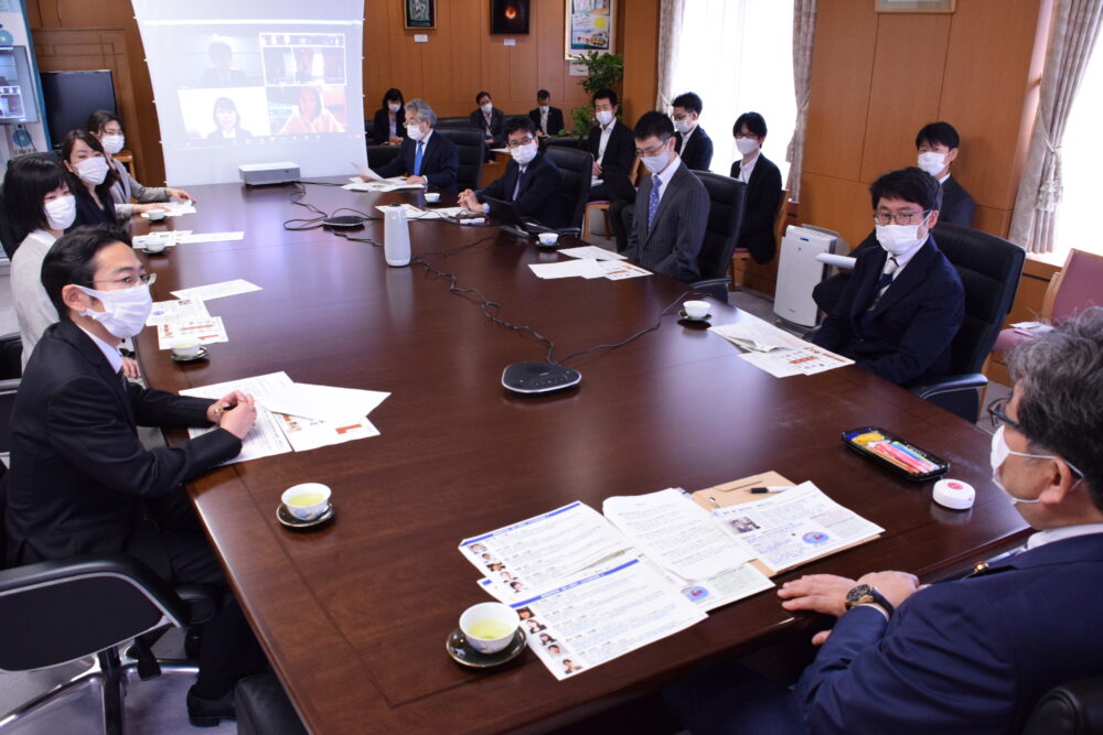 大きな長方形のテーブルを囲むように、当日の参加者と萩生田文科大臣が座って談話する様子。