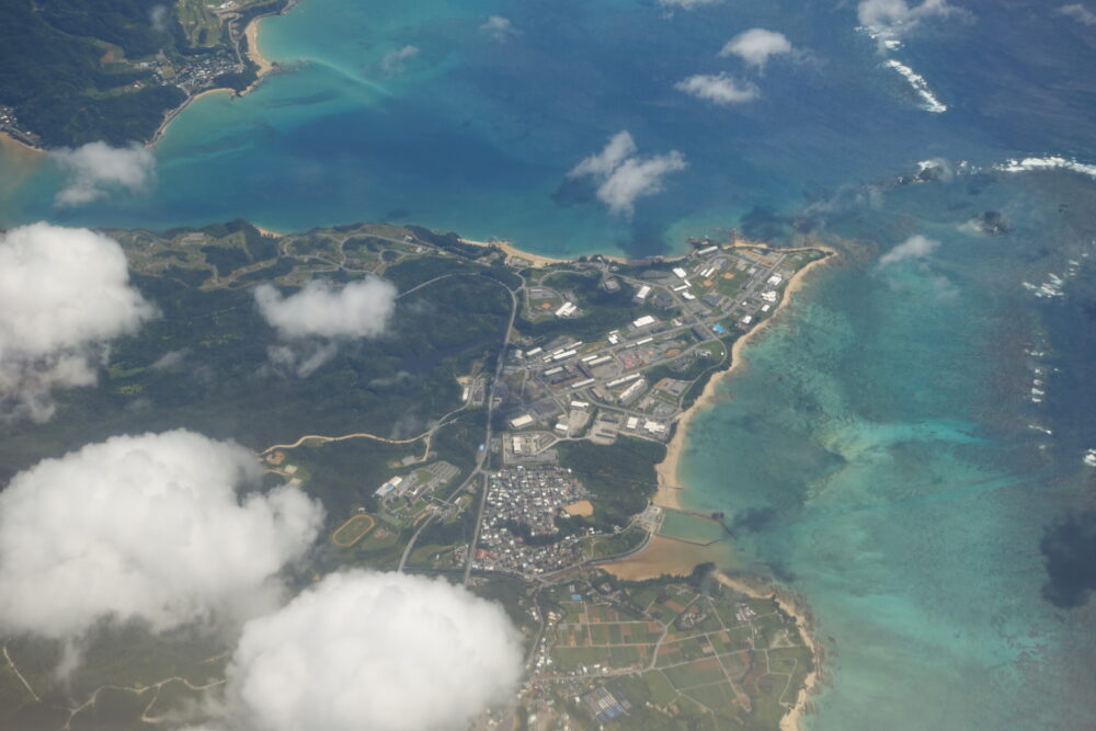 水色・青・緑のグラデーションが美しい沖縄の海と、緑豊か陸地。