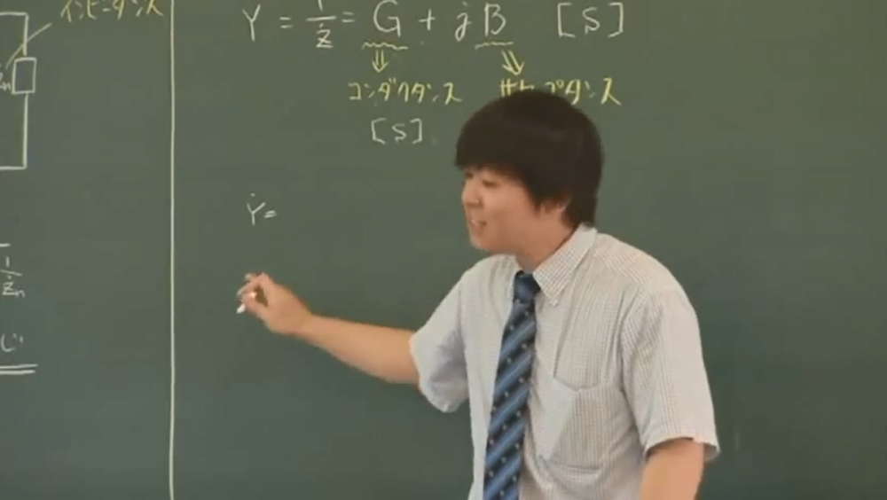 黒板にチョークを持ち、授業を行っている福田先生