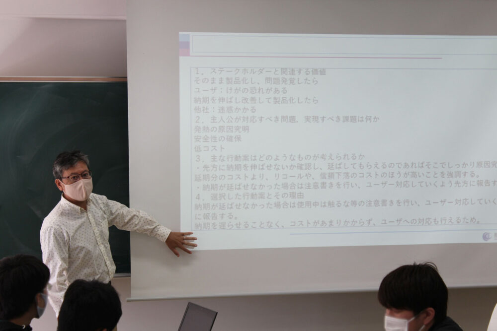 スクリーンに映したスライドを説明しながら授業を行う小林先生。