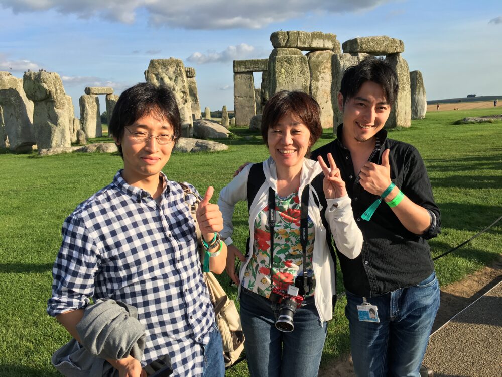 ストーンヘンジのような、石のモニュメントを背景に、工藤先生、市川先生とポーズ