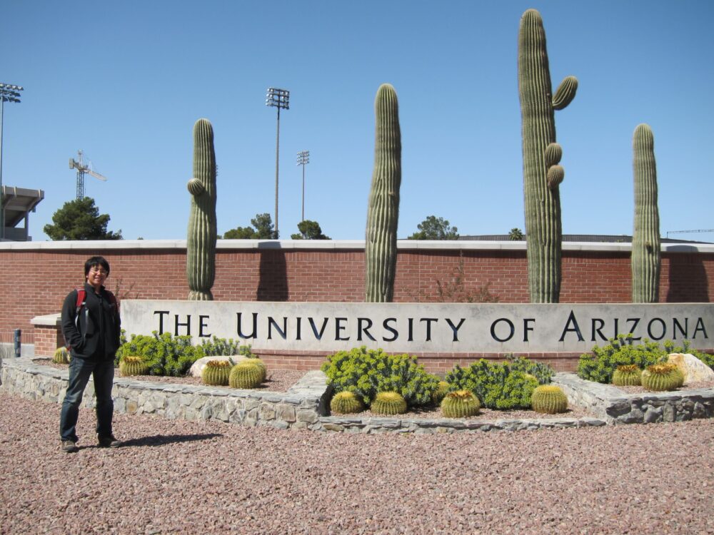 アリゾナ大学と英語で表記された学校の看板とともに。大きなサボテンが印象的