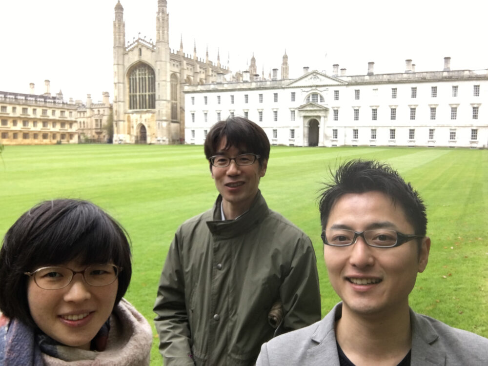 ケンブリッジ大学の伝統的な建築物を背景に、三原先生と吉沢先生とともに