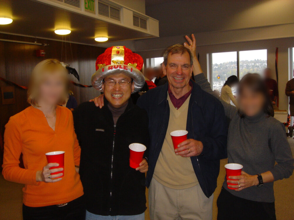 赤色と金色の大きな帽子をかぶった野村先生。アメリカでのハロウィンパーティーの様子。