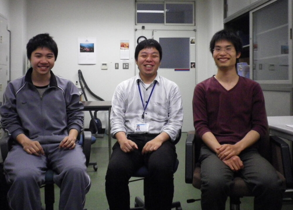 真ん中に座る青木先生と、左右それぞれに座る研究室1期生の学生2名