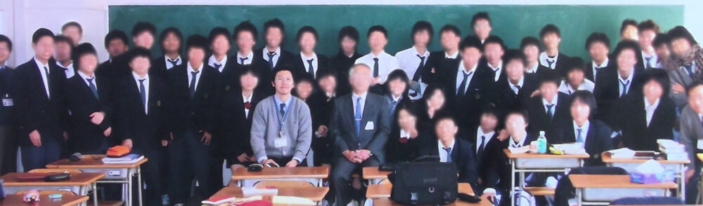 教室で、制服姿の学生40名ほどと集合写真