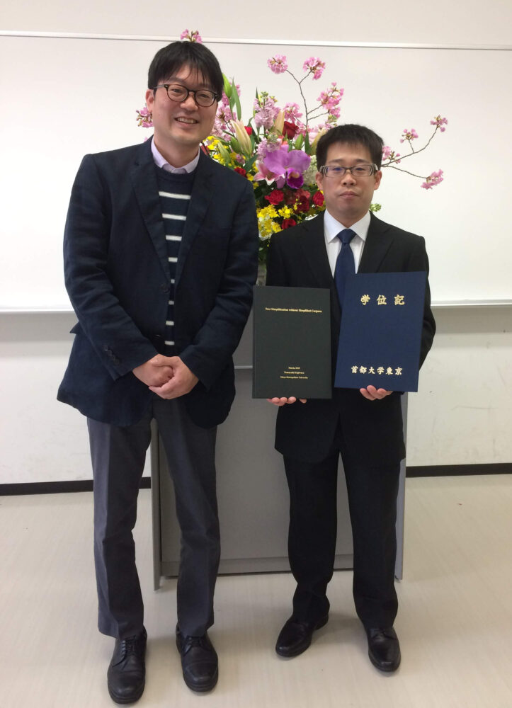 学位記等を手に持ち、恩師である町田先生と記念撮影