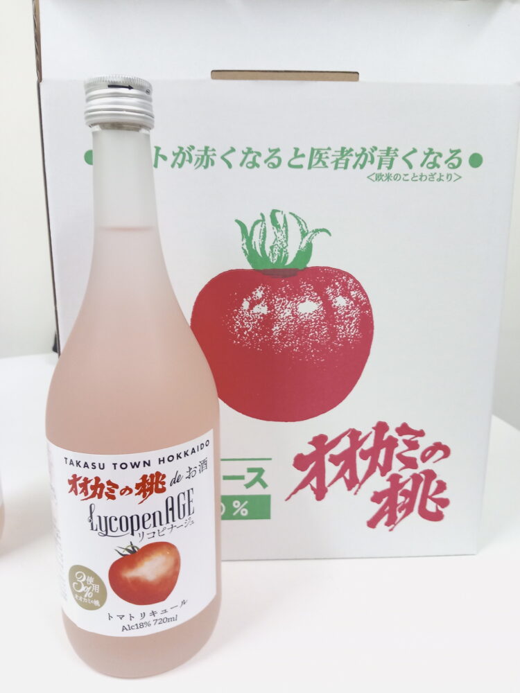 トマトの絵が描かれた白色の紙パッケージと、淡いピンク色の液体が入った瓶
