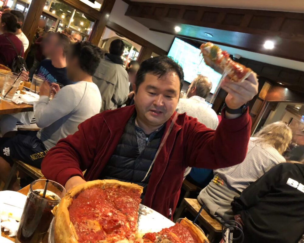 シカゴのレストランで、ワンピースが顔の大きさほどある巨大なピザを堪能する徳楽先生
