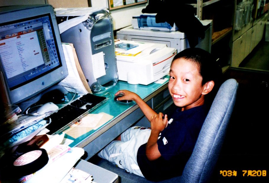 パソコンの前で微笑む小学生の任田先生