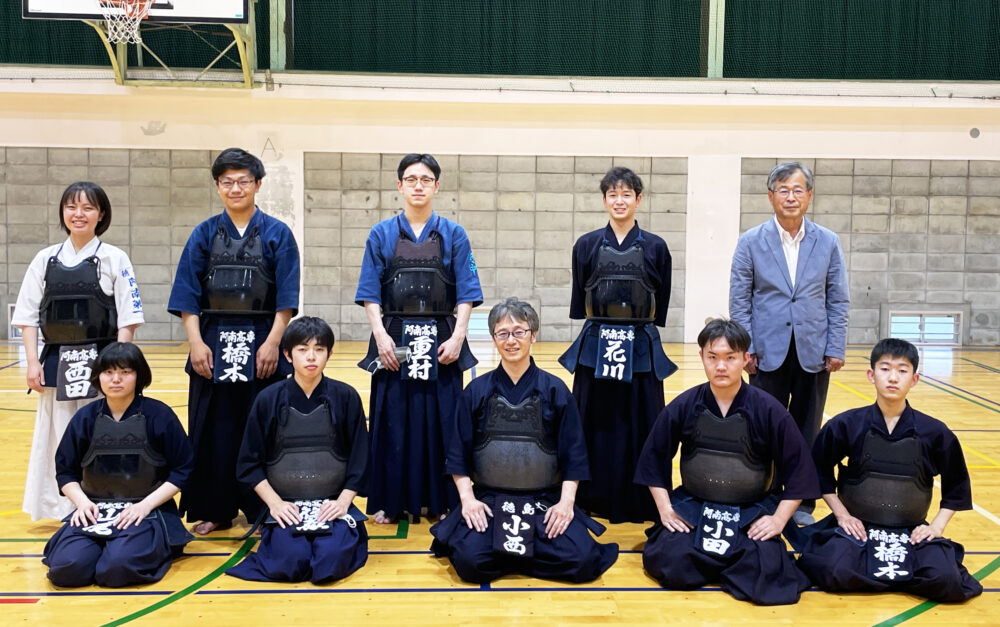 剣道の道着を着て写真に写る小西先生と学生のみなさま