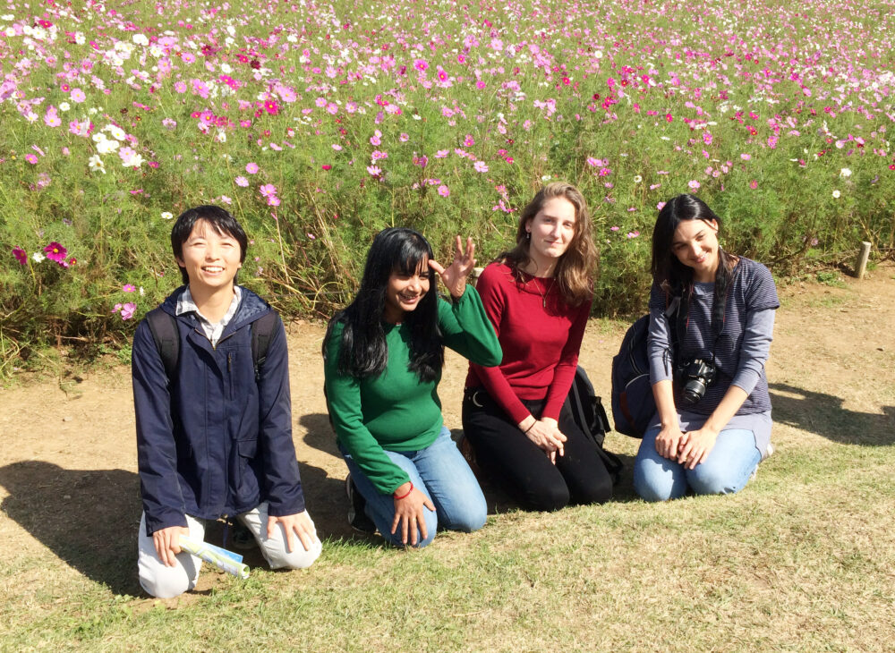 コスモスの花の前で写真に写る貴嶋先生と、ご友人３名
