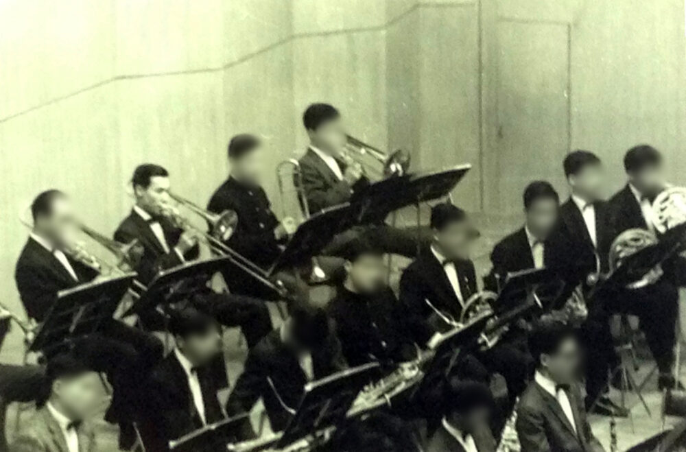 トロンボーンを吹く島田先生と、オーケストラの人々