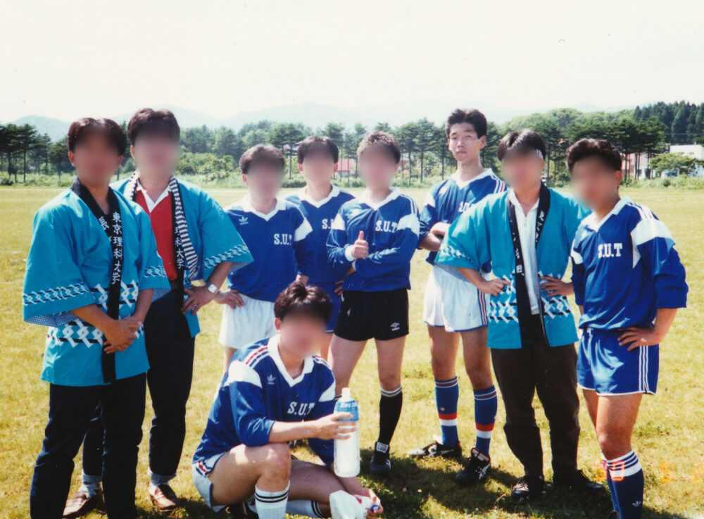 サッカー部の仲間たちとともに写真に写る飯島先生