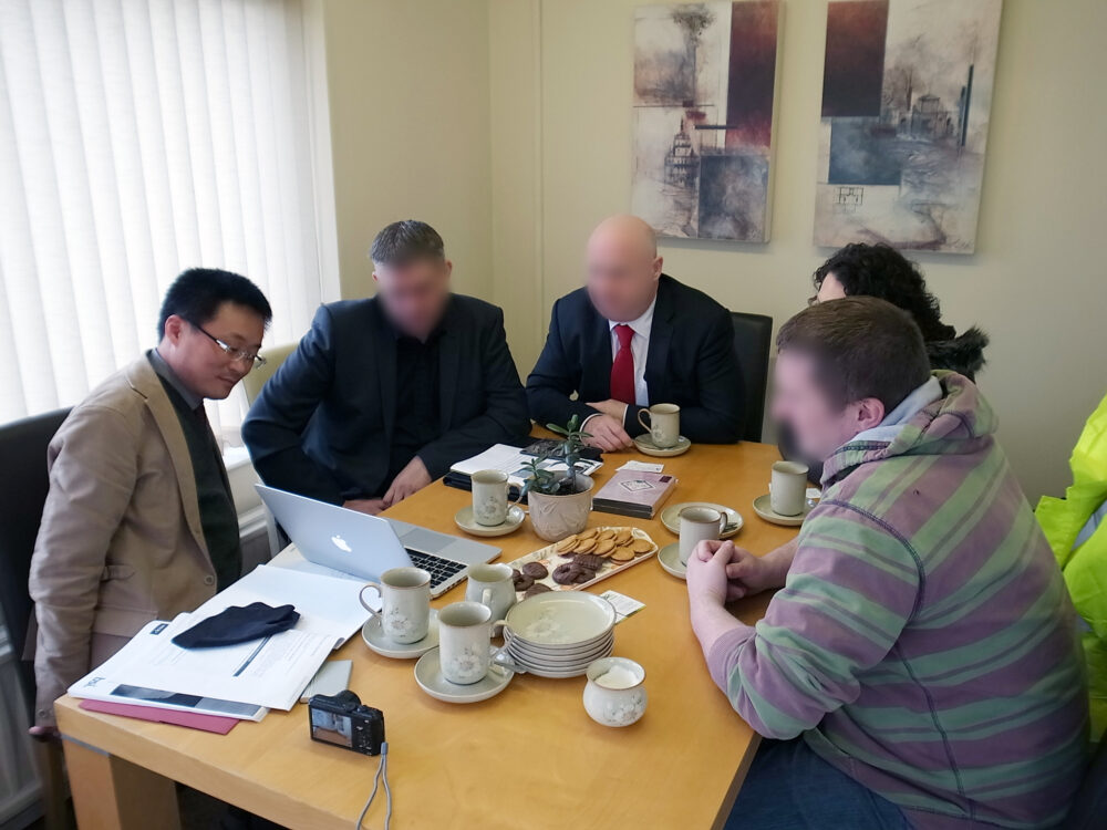 北アイルランドの方４名と、テーブルでパソコンを見ながら話をする袋布先生