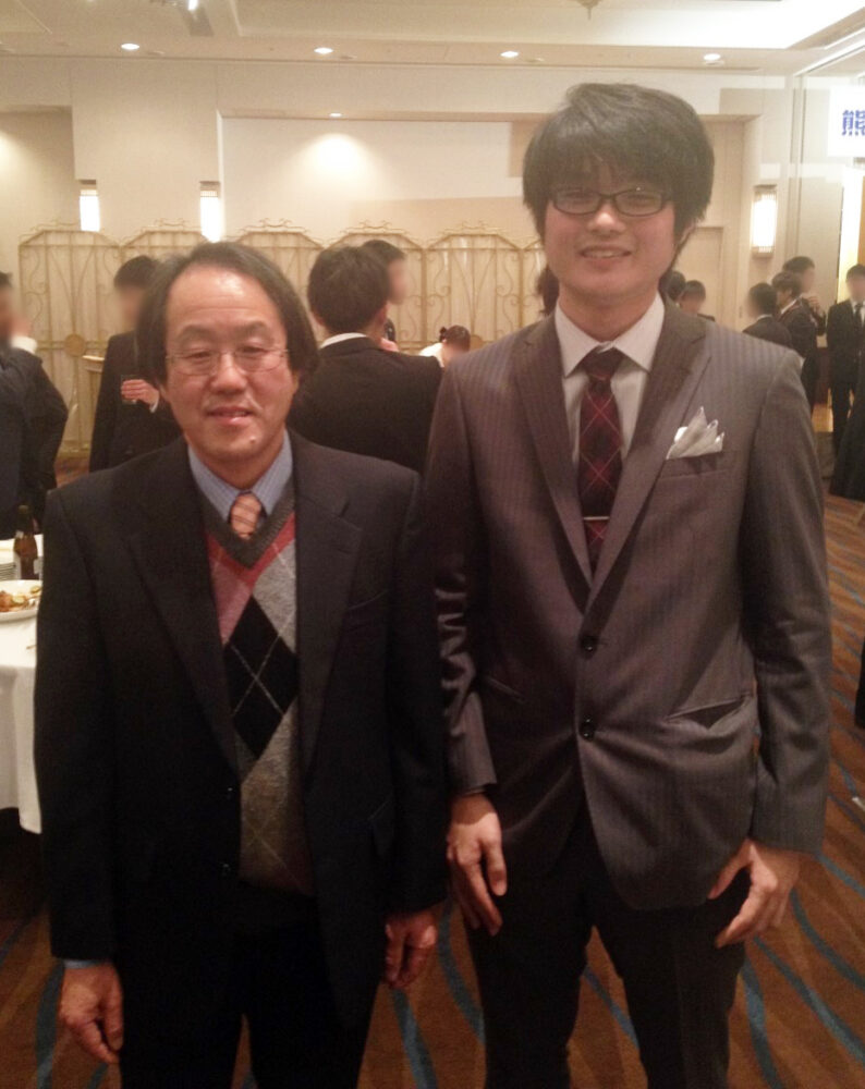 スーツ姿で写真に写る古里先生と秋山先生