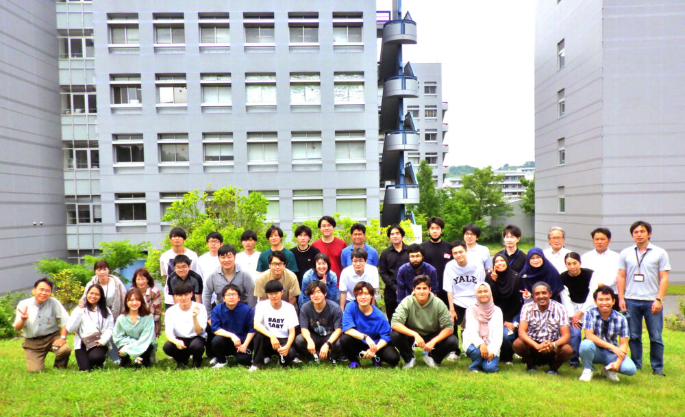 芝生の上で並んで写真に写る、浦岡研究室の学生の皆さま