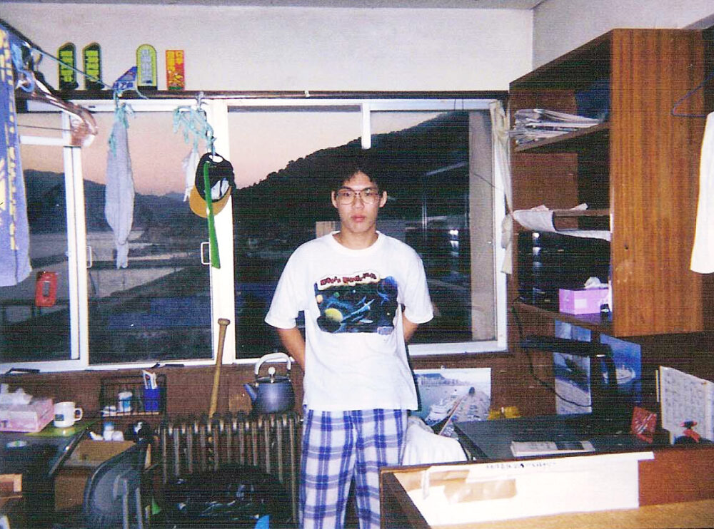 学生寮でTシャツを着て、窓際で写真に写る前畑先生