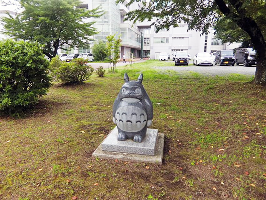 八戸高専の木のそばにたたずむトトロの像