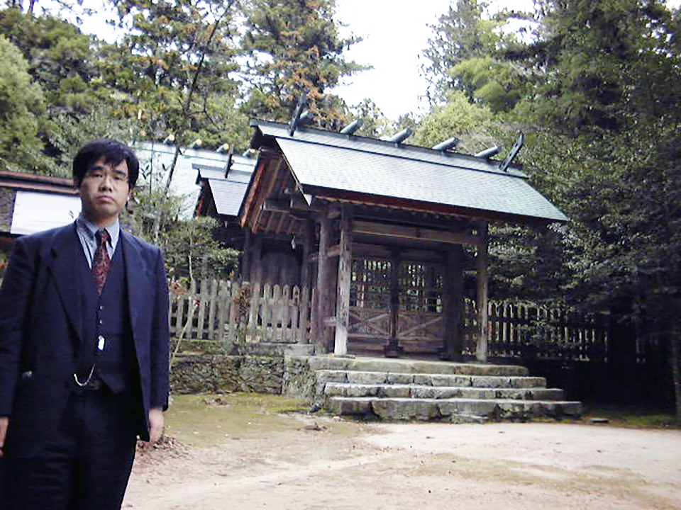 神社の前で写真に写る冨田先生
