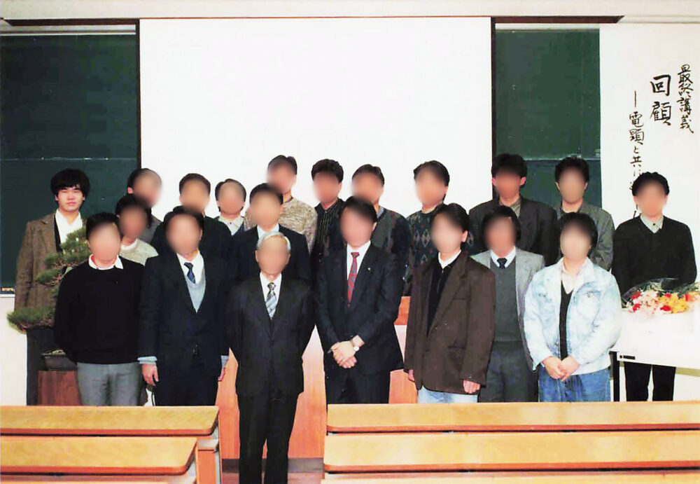 黒板の前で写真に写る冨田先生と恩師の方、大学のみなさま