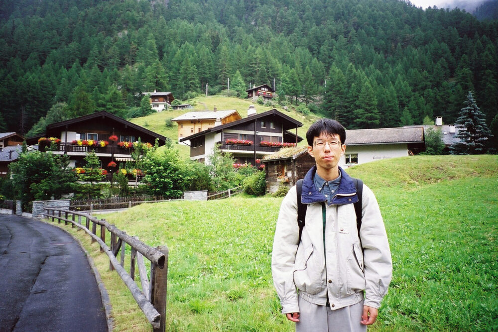 スイスの山のふもとで写真に写る佐藤先生