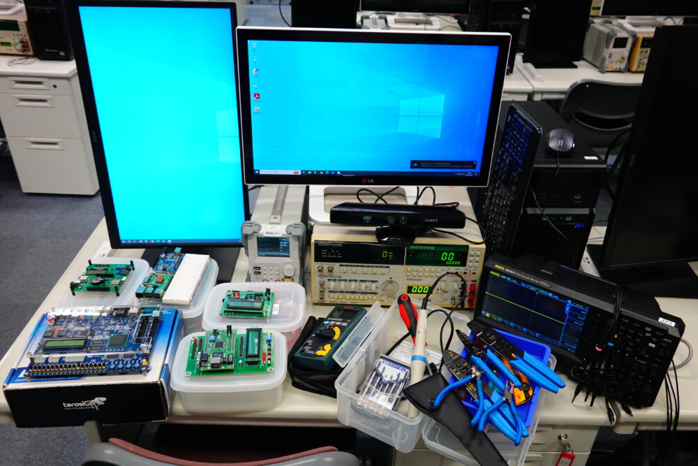 組み込みシステム開発電算室の各デスクに用意されている測定器や工具、マイコンなど