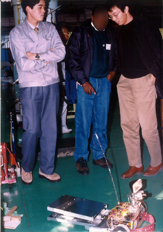 ▲高専教員のころ、ロボットのデモにて。3人いる。左は当時津山高専教員だった赤木先生（現・岡山理科大学 工学部 知能機械工学科 教授）