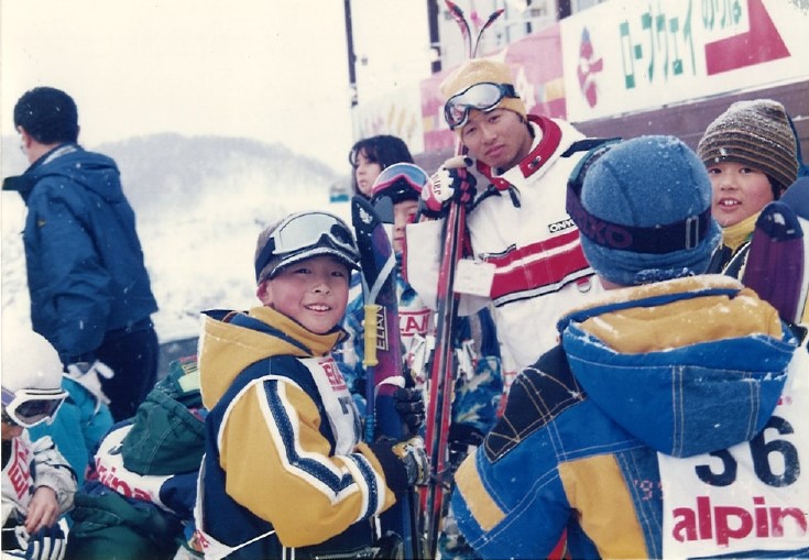 大学院修士課程では、スキーの教師もされていた飯塚先生。スキーウェアを着て子供と写っている