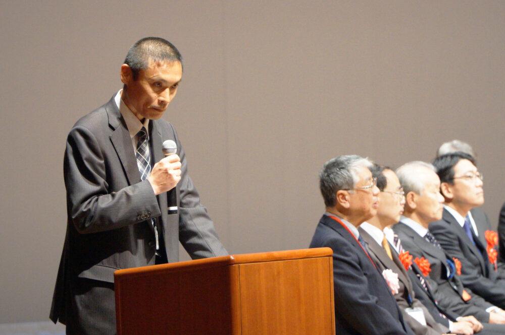 第26回高専プロコンの閉会式で司会を務める長尾先生の様子。