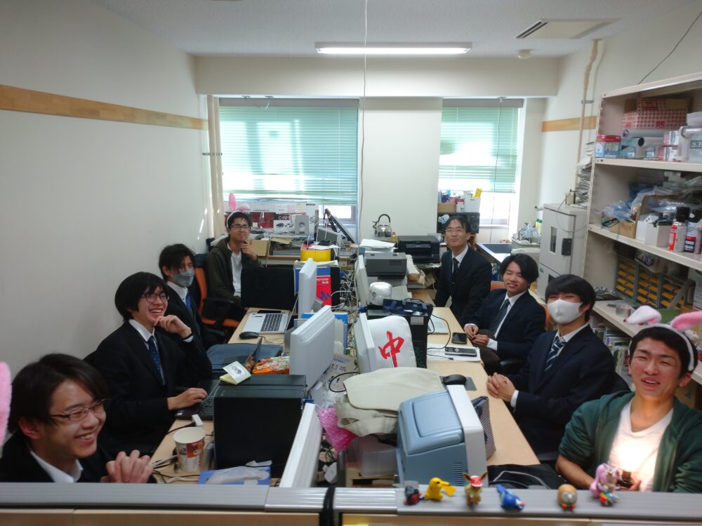 渡辺先生の研究室。学生と先生がにこやかに笑っている