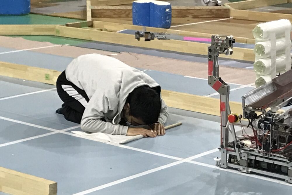 ロボコンサークルでつくったロボットが無事に動くようお祈りをする小林先生