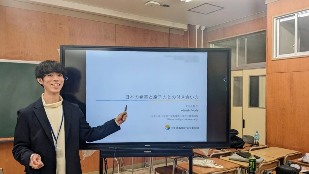 新潟県長岡市の高校で出前授業を行った野田さん。スクリーンを指しています