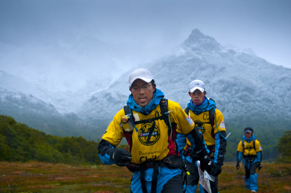 2012年のPERにて。自然の中をチームで列になって歩く様子。バックには山岳が写っている。