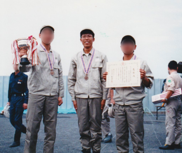 会社の消防訓練大会に参加された田中さん。表彰を受けて記念撮影。メダルをかけている。