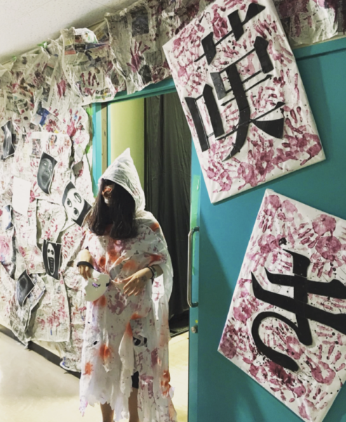 富山高専の学祭「北斗祭」にて、お化けに扮する宮下さん。白いビニール合羽を着て包帯を顔に巻いて長い髪を前に垂らしている。