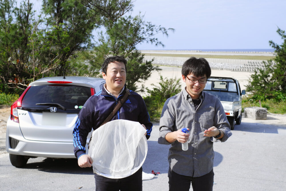 海岸沿いで並んで写真に写る藤井先生と伊達先生