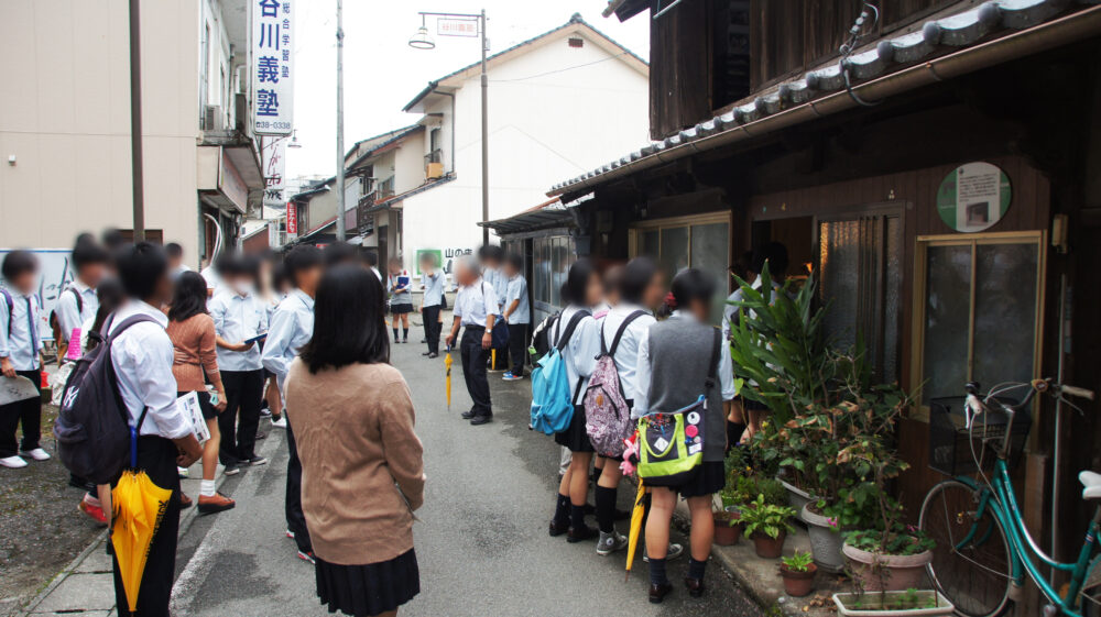 屋外でフィールドワークを行う熊本高専の学生たちの様子