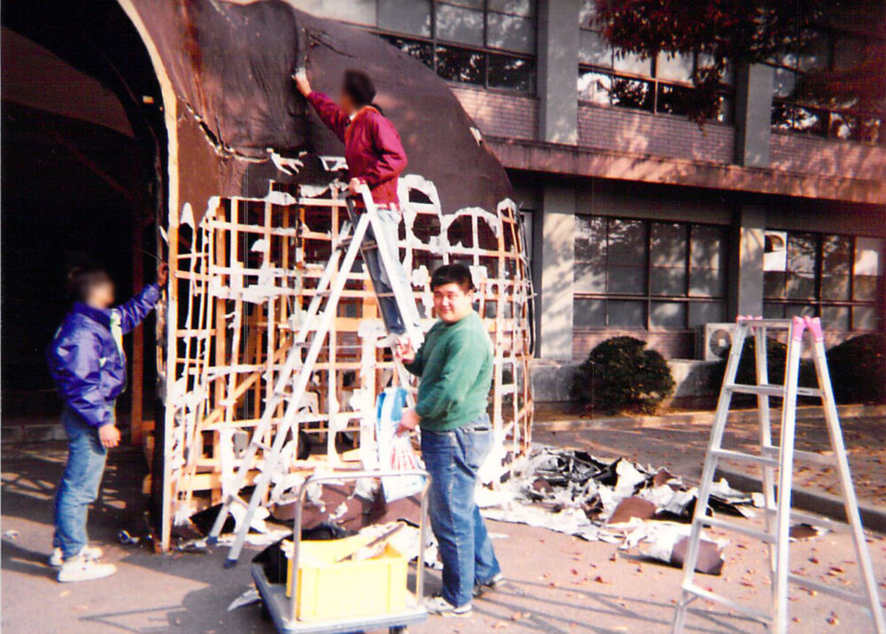 学園祭の準備中。友人二人とともに建物を作っているところ。