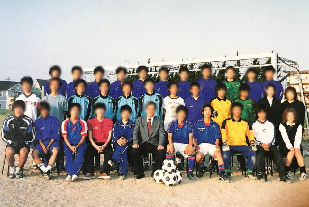 サッカー部のメンバーと一緒に最前列で集合写真に写る富山商船５年生の時の津田興利さん