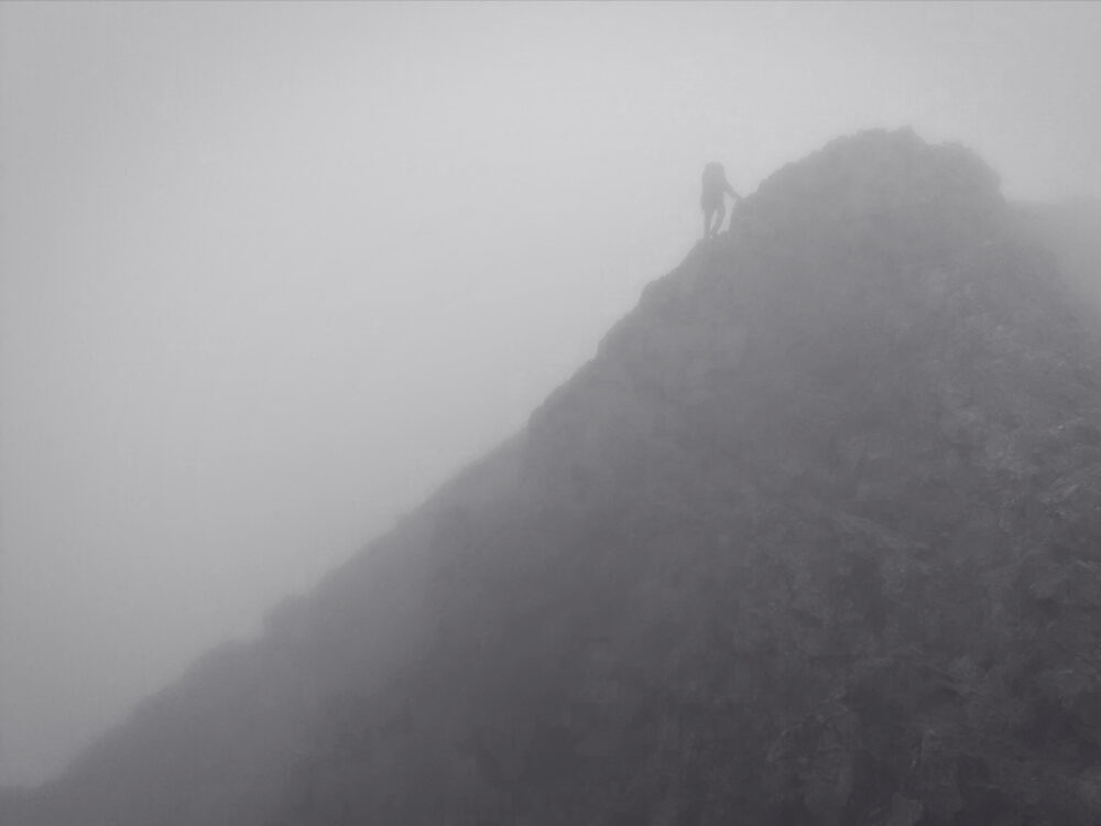 視界が悪い山岳をパトロールしている人物と山容の様子