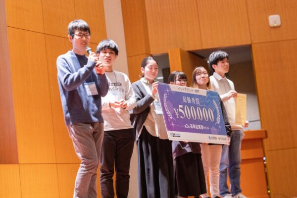 イントラプレナー部門 最優秀賞を受賞し、コメントをする田坂さんと、チームメンバーのみなさん