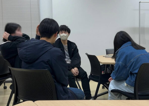 コンテスト同好会にて、メンバーとコミュニケーションをとる佐藤さん。