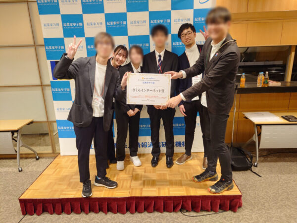 「令和5年度起業家甲子園」で猿渡さん(当時高専生)と片野さんのチームがパートナー企業特別賞(さくらインターネット賞)を受賞したときの集合写真。高専プロコンにも参加しており、アイデアを形にすることにチャレンジしてきました
