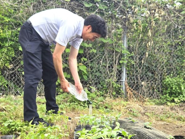 苗に水やりをする森田先生。カボチャやトウモロコシ、ささげ豆などの苗を育てており、大分駅前にある祝祭の広場内に植える予定とのことです（取材当時）。