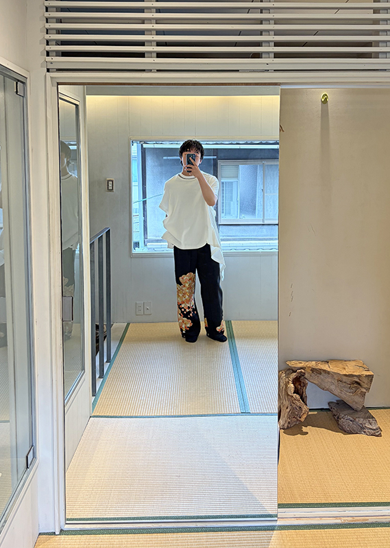 大阪のセレクトショップにて鏡を前に自分の服装の写真を撮る様子